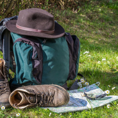 Zainetto, mappa, cappello e scarpe da trekking.