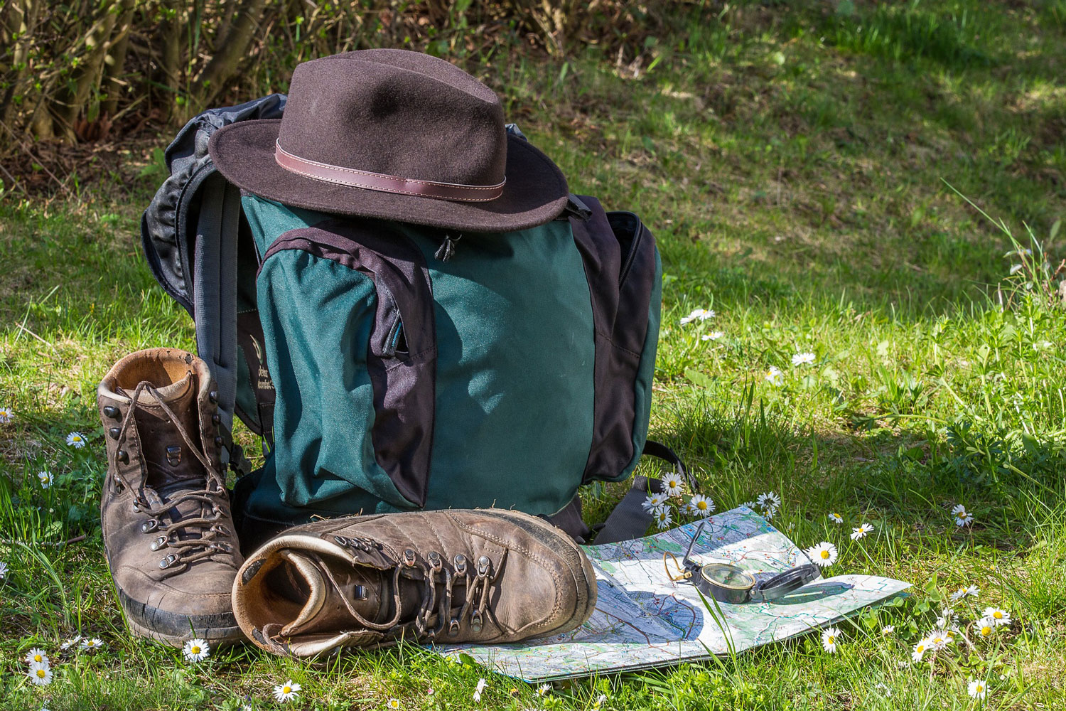 Zainetto, mappa, cappello e scarpe da trekking.